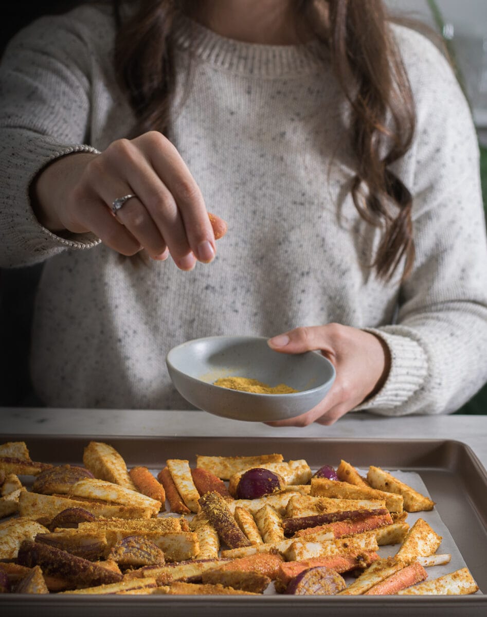 Marie-Eve saupoudre de la levure nutritionnelle sur des légumes